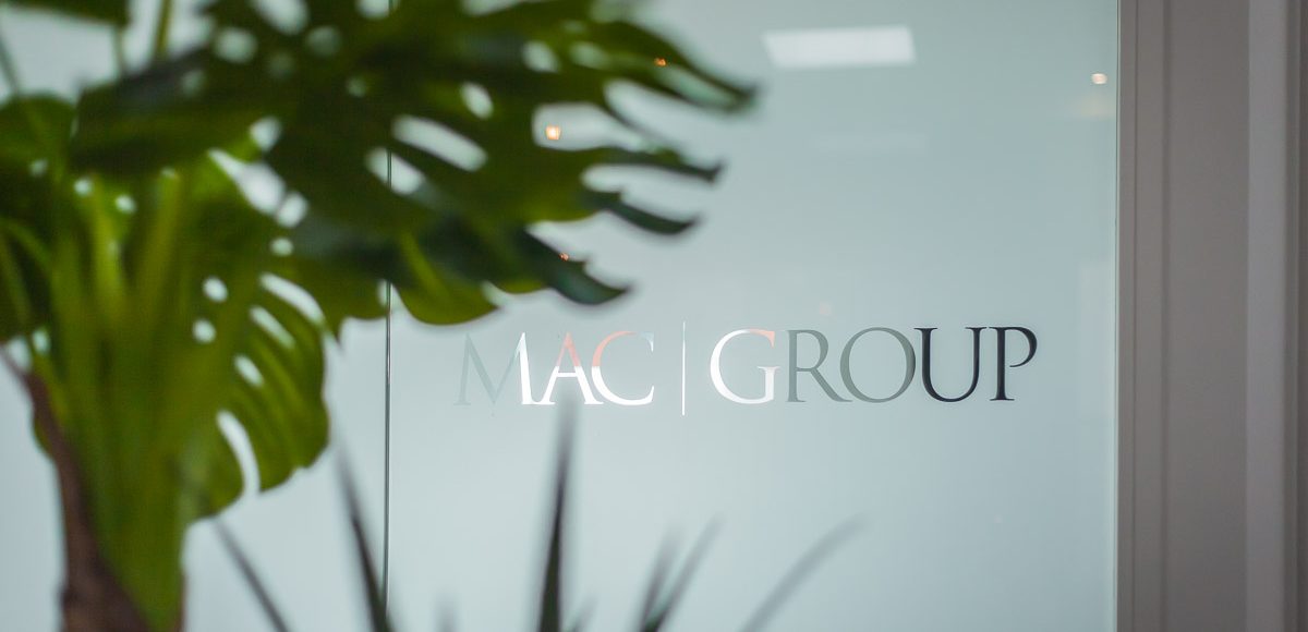 A photo of frosted glass with the wording MAC Group on it