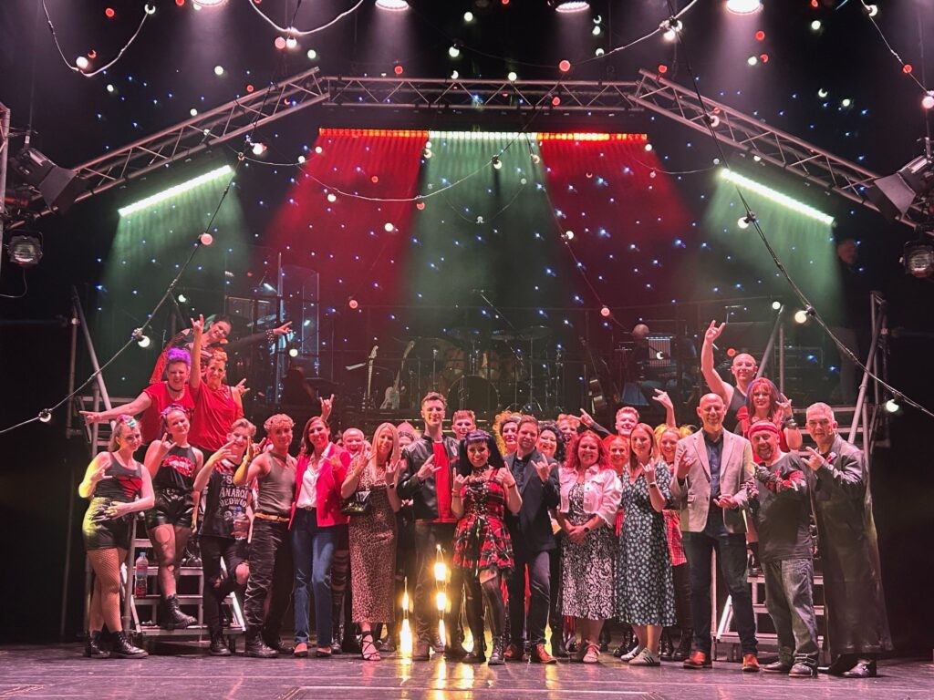 A photo of the We Will Rock You cast with representatives from MAC 