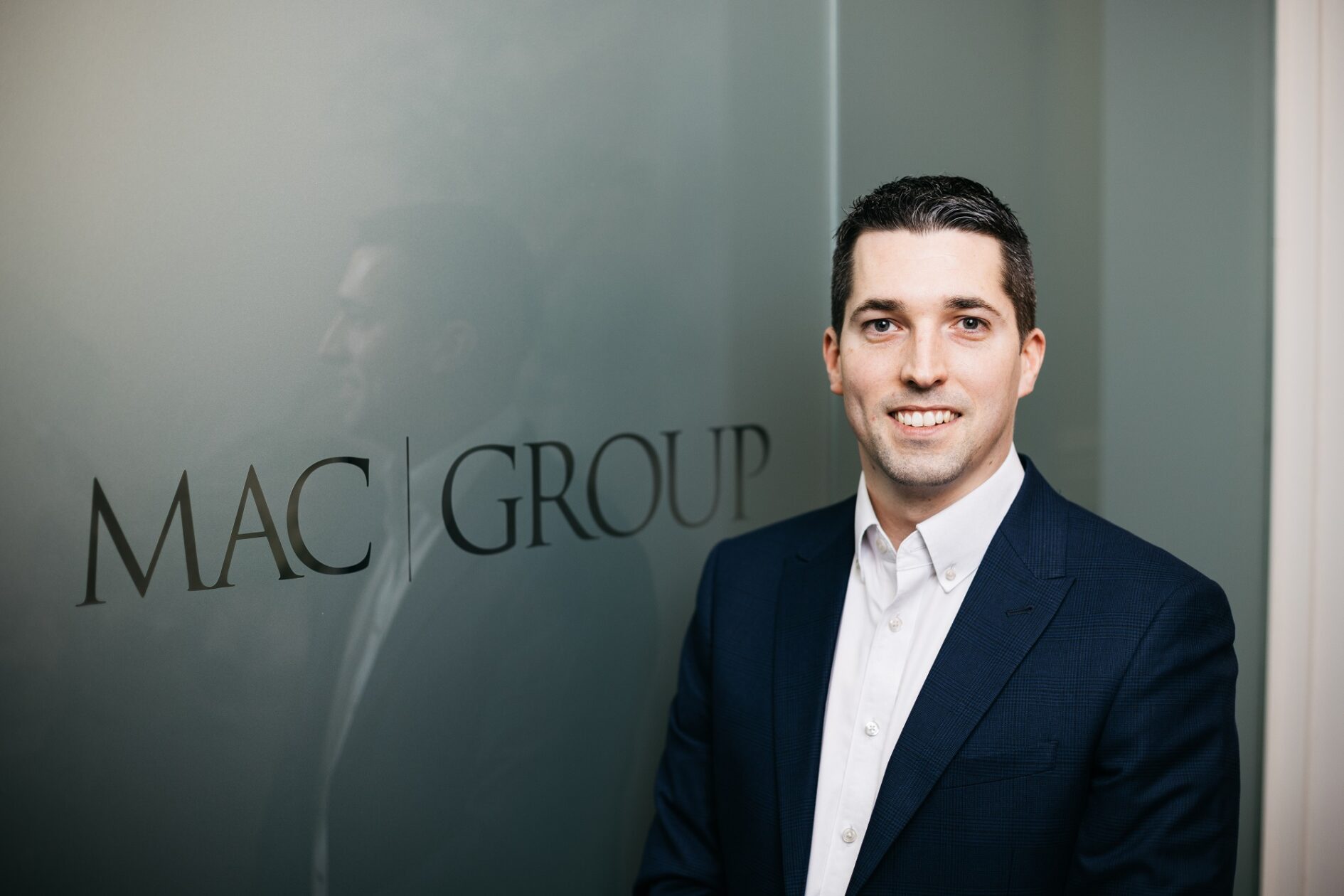 Landscape portrait of Mike Stronger next to MAC sign